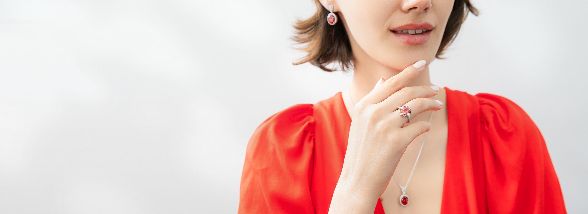 Model wearing red ring, necklace and earrings.