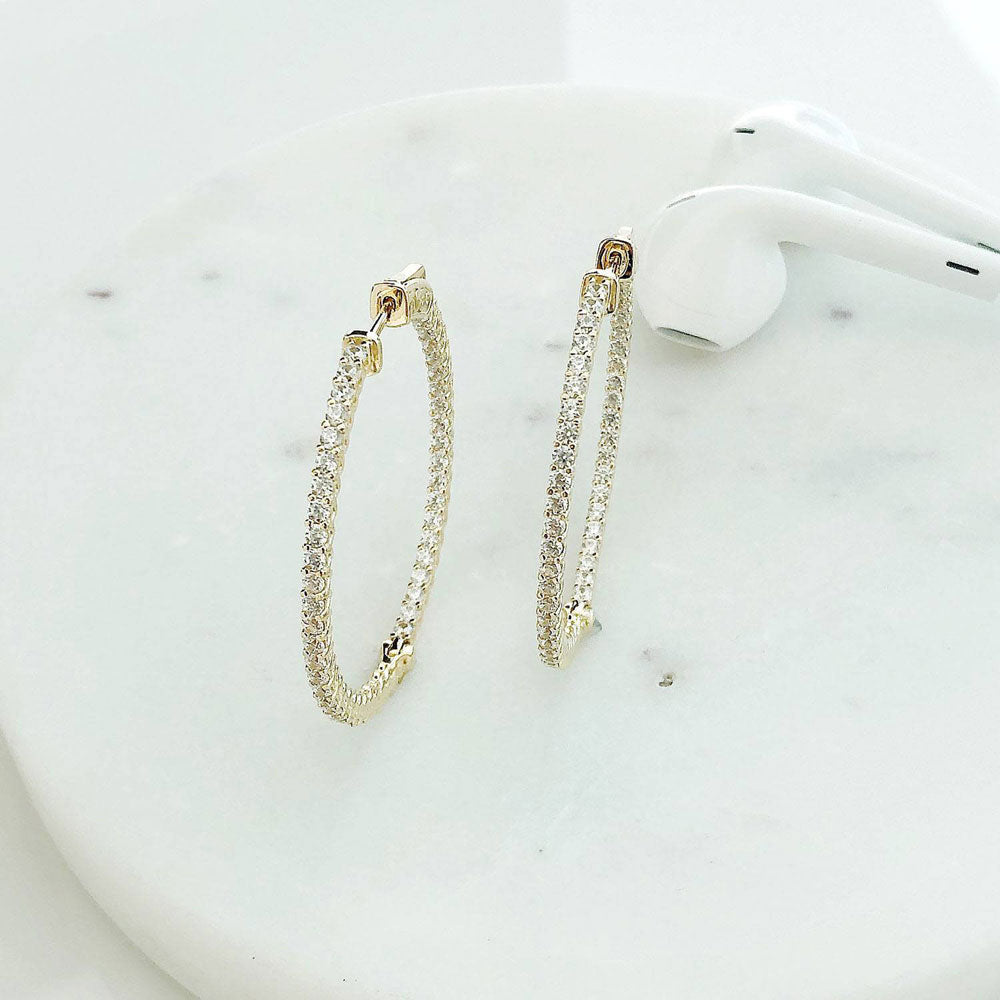 Flatlay view of CZ Medium Inside-Out Hoop Earrings in Sterling Silver 1.4 inch, Yellow Gold Flashed