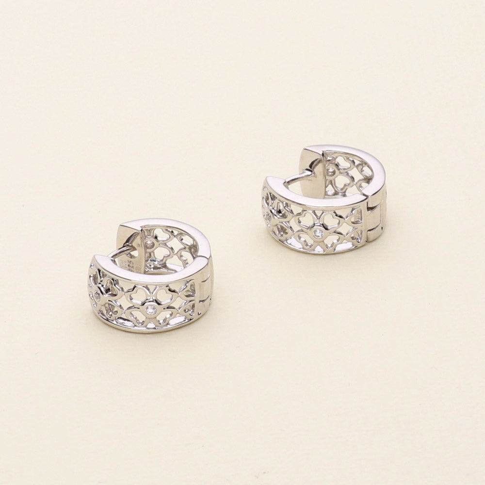 Flatlay view of Clover CZ Small Huggie Earrings in Sterling Silver 0.55 inch, Rhodium Plated