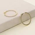 Flatlay view of CZ Medium Inside-Out Hoop Earrings in Sterling Silver 1.4 inch, Yellow Gold Flashed