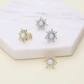 Flatlay view of Sun Sunburst Simulated Opal CZ Stud Earrings in Sterling Silver