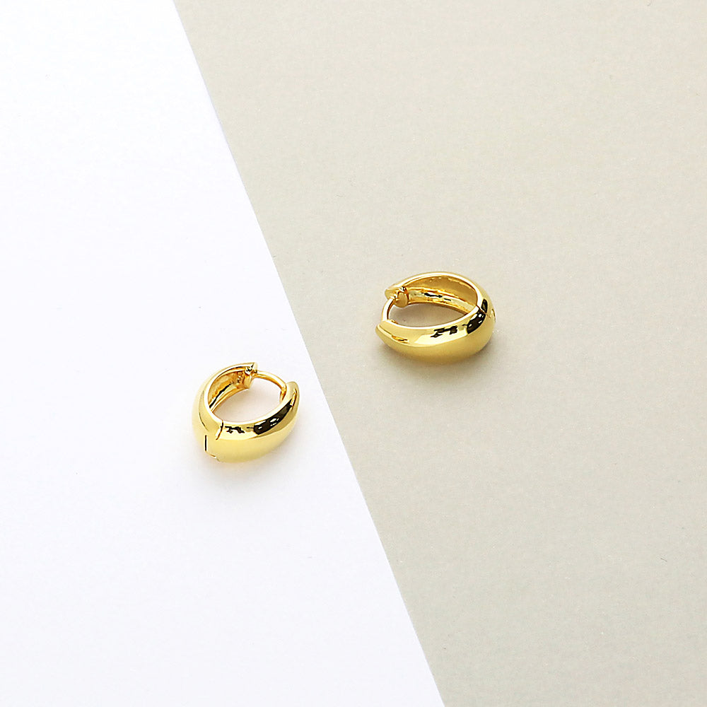 Flatlay view of Oval Dome Medium Huggie Earrings in Sterling Silver 0.63 inch, Yellow Gold Flashed