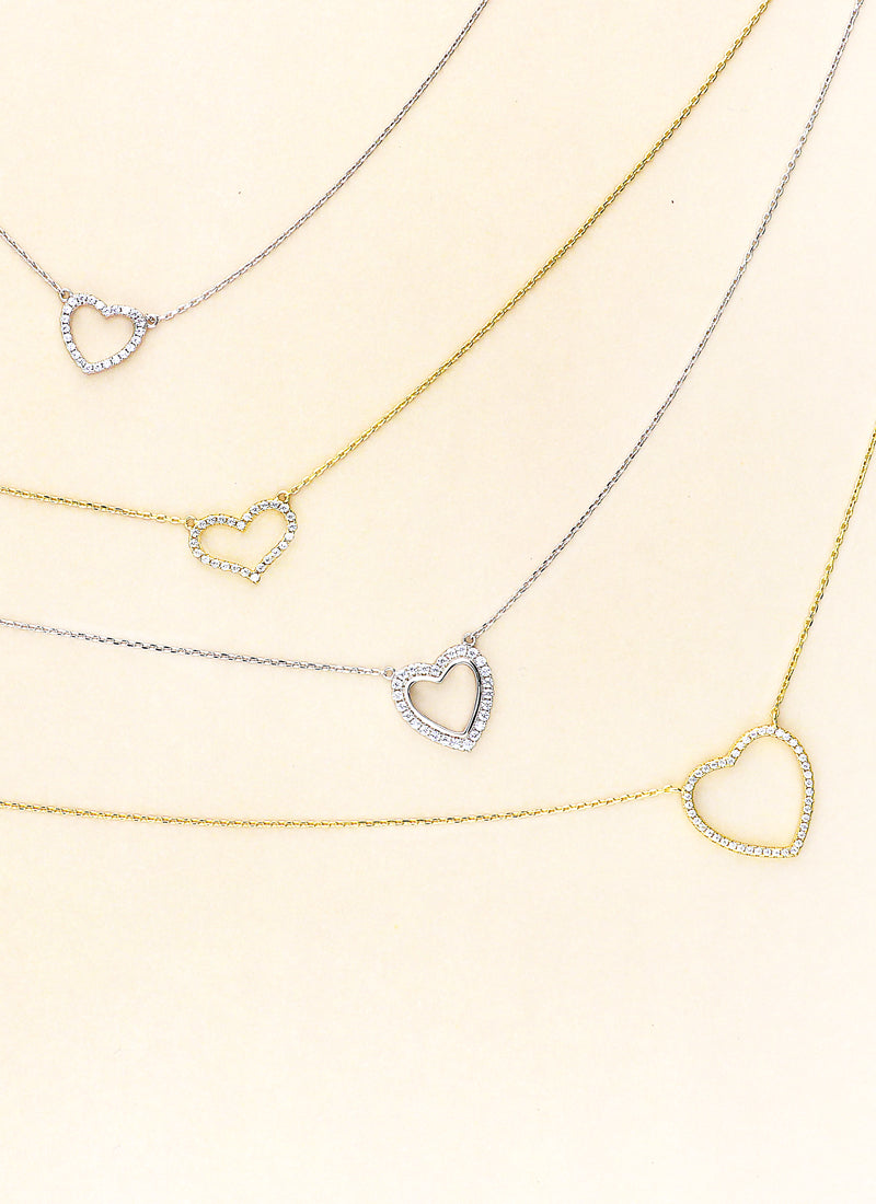 Heart necklaces on a cream color background.