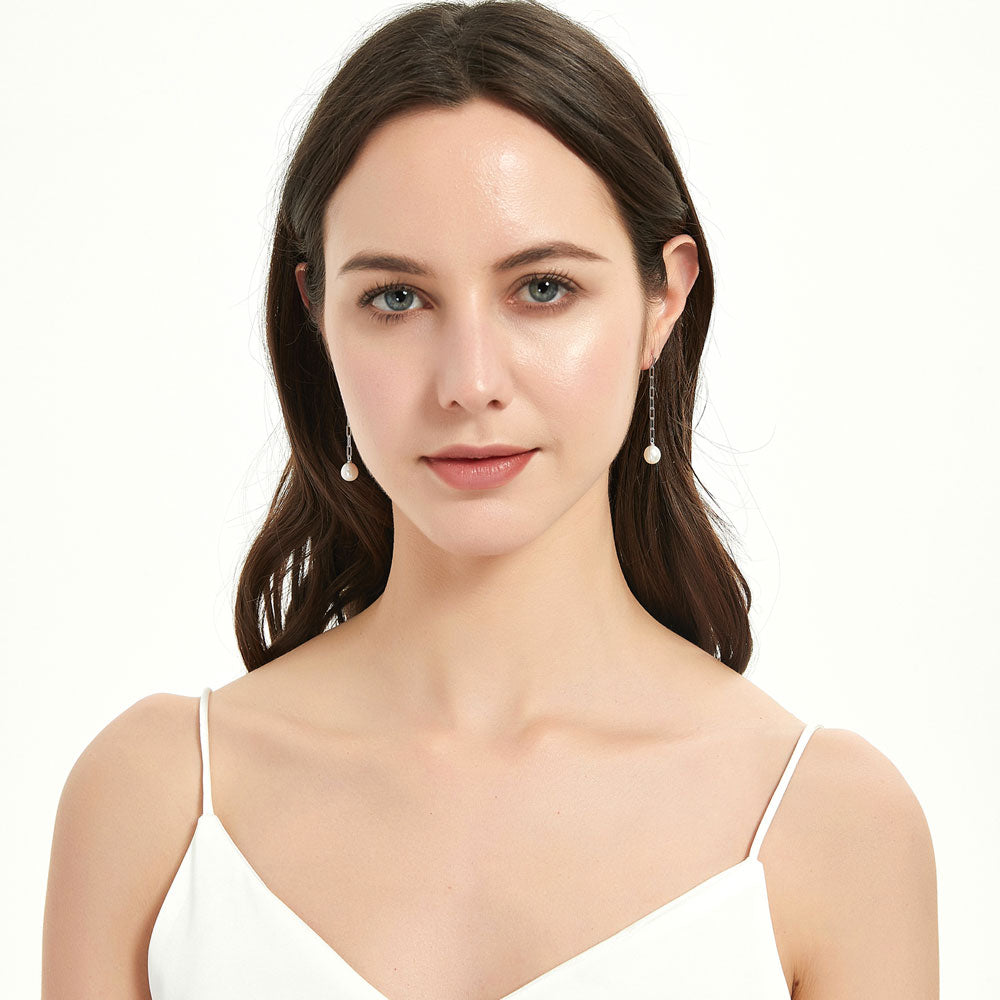 Model wearing Solitaire Oval Cultured Pearl Earrings in Sterling Silver, Rhodium Plated