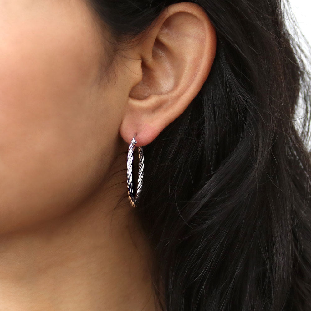 Model wearing Cable Medium Hoop Earrings in Sterling Silver 1.2 inch, 2 of 10