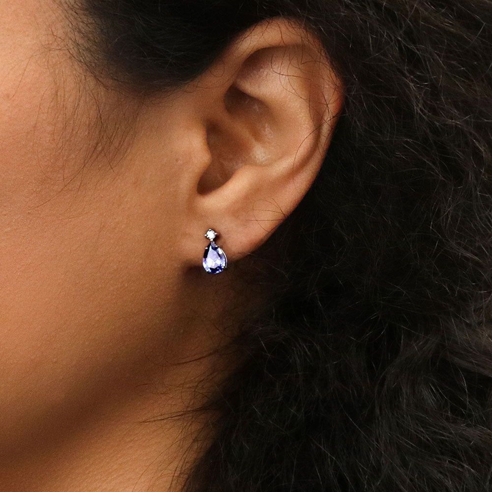 Model wearing Solitaire 2-Stone Pear Stud Earrings in Sterling Silver 1.4ct, Tanzanite Color