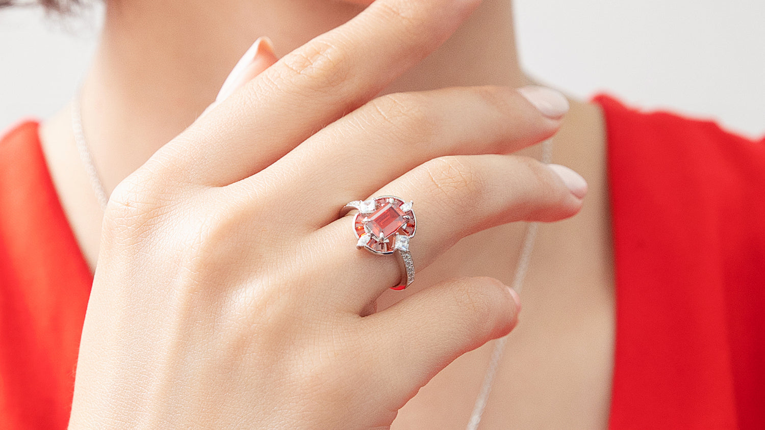 model wearing red birthstone ring