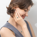 Model wearing Flower Halo CZ Necklace and Earrings in Sterling Silver, Emerald Color