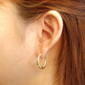 Model wearing Oval Medium Hoop Earrings 0.9 inch, Silver-Tone