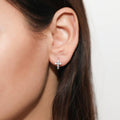 Model wearing Cross CZ Small Huggie Earrings in Sterling Silver 0.5 inch, Yellow Gold Flashed