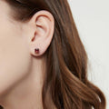 Model wearing Solitaire Kaleidoscope CZ Stud Earrings in Sterling Silver 2.5ct, Red Orange Color