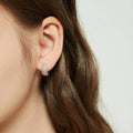 Model wearing CZ Small Huggie Earrings in Sterling Silver 0.5 inch, Morganite Color