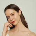 Model wearing Cross CZ Small Huggie Earrings in Sterling Silver 0.5 inch, Yellow Gold Flashed