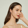 Model wearing Cross CZ Small Huggie Earrings in Sterling Silver 0.5 inch, Yellow Gold Flashed