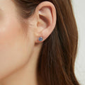 Model wearing Solitaire Kaleidoscope CZ Stud Earrings in Sterling Silver 1.6ct, Purple Aqua Color