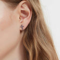 Model wearing Cross CZ Stud Earrings in Sterling Silver, Red Color