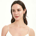 Model wearing CZ Large Inside-Out Hoop Earrings in Sterling Silver 2.5 inch, Yellow Gold Flashed