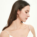 Model wearing Oval Bar CZ Medium Hoop Earrings in Sterling Silver 0.65 inch, Yellow Gold Flashed