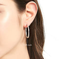 Model wearing Bar CZ Medium Hoop Earrings in Sterling Silver, 1.25 inch