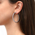 Model wearing CZ Large Inside-Out Hoop Earrings in Sterling Silver 1.9 inch, Rhodium Plated